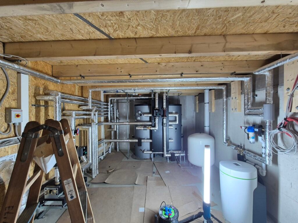 Rohrleitungen und Speicher unter einer sichtbaren Holzdecke