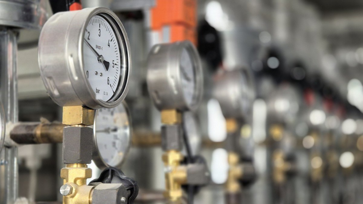 Armaturen und Manometer an der Wärmeverteilung einer Heizzentrale im Bestand